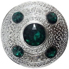 A plaid brooch featuring an embossed Celtic design green stone