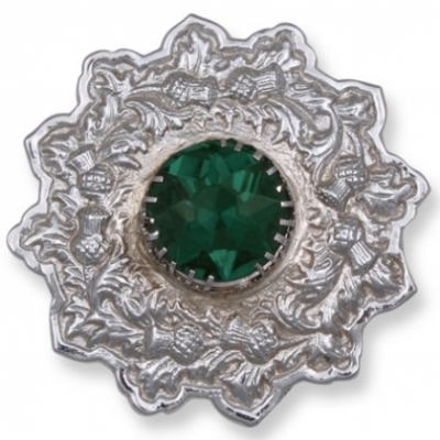 A plaid brooch featuring an embossed thistle design green stone