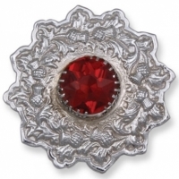 A plaid brooch featuring an embossed thistle design red stone